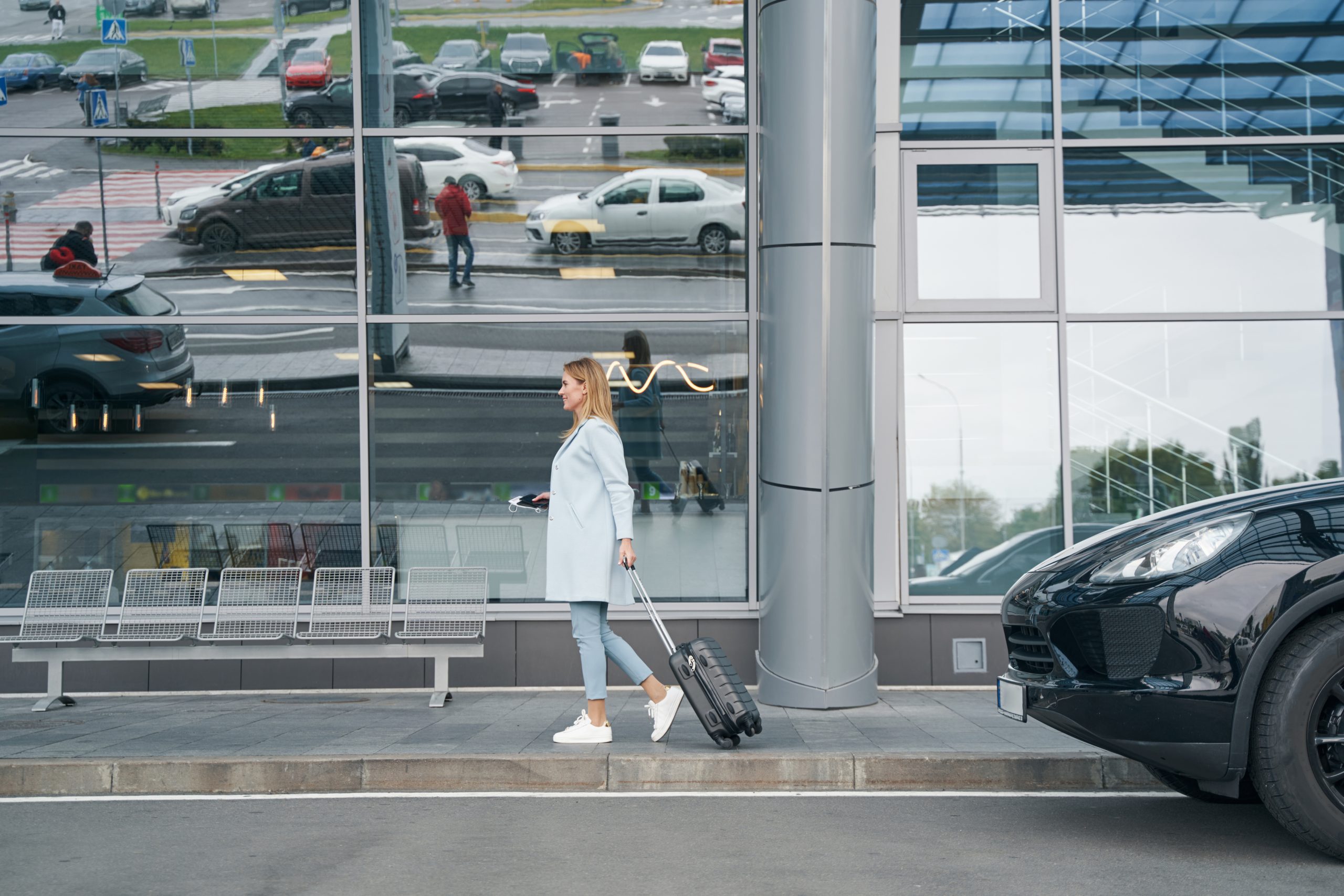 Voyageuse avec valise devant un terminal avant un transfert en taxi vers Bruxelles-Zaventem